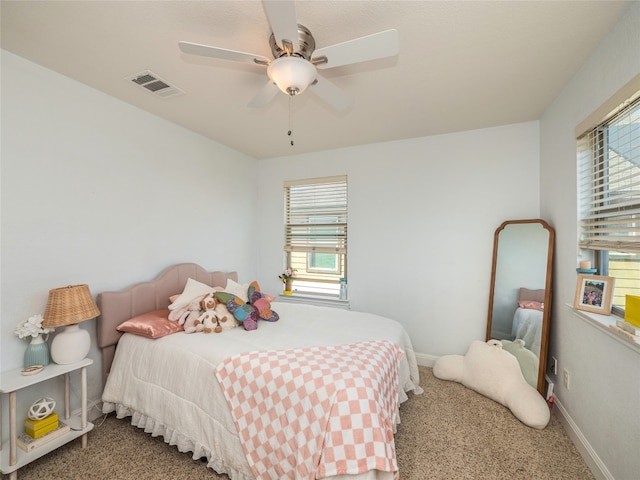 carpeted bedroom with visible vents, ceiling fan, baseboards, and multiple windows