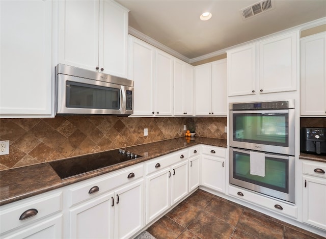 kitchen with stainless steel appliances, visible vents, backsplash, white cabinets, and dark stone counters