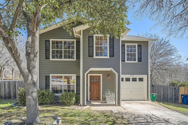 view of front of property featuring driveway, an attached garage, and fence