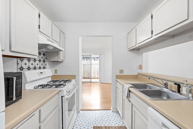 kitchen with light countertops, white appliances, a sink, and under cabinet range hood