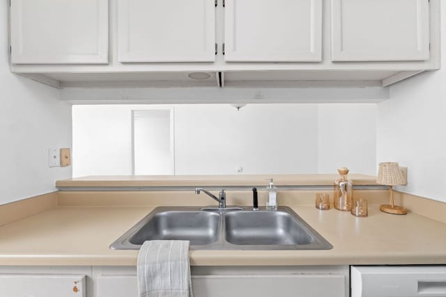 kitchen featuring light countertops, white dishwasher, and a sink