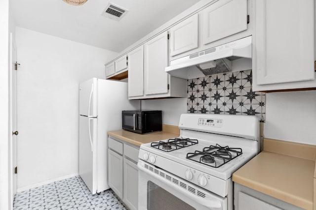 kitchen featuring light floors, light countertops, visible vents, white appliances, and under cabinet range hood