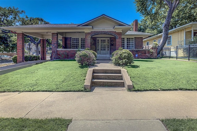 view of front facade featuring fence, a front lawn, and brick siding