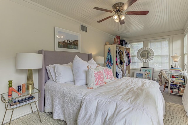 bedroom with carpet floors, visible vents, ornamental molding, wood ceiling, and ceiling fan