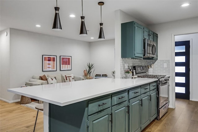 kitchen with backsplash, stainless steel microwave, light wood-style flooring, and gas range oven