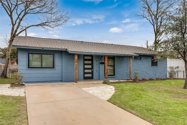 view of front of home featuring covered porch, fence, a front lawn, and roof with shingles