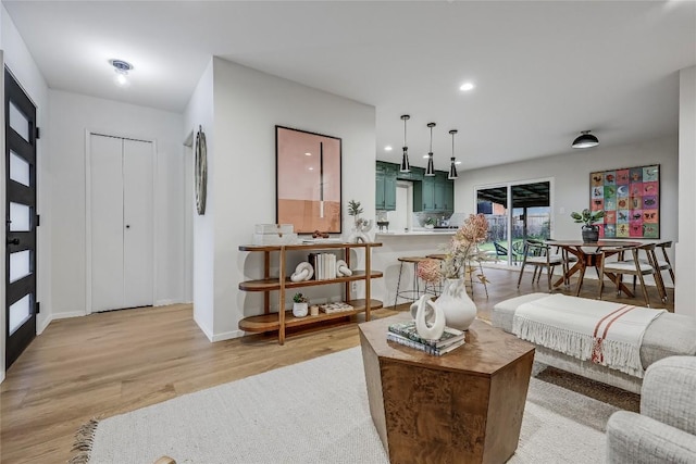 living room with light wood-style floors, recessed lighting, and baseboards