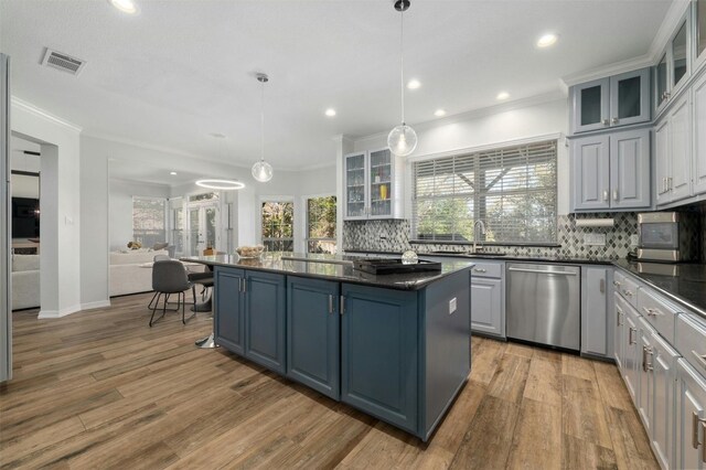 9288 Scenic Bluff Dr, Austin, TX 78733 - kitchen featuring stainless steel dishwasher, dark countertops, ornamental molding, backsplash, and a kitchen island