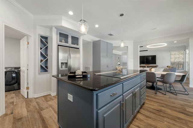 9288 Scenic Bluff Dr, Austin, TX 78733 - kitchen featuring washer / clothes dryer, stainless steel refrigerator with ice dispenser, crown molding, a center island, and wood finished floors