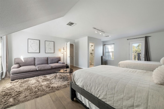 9288 Scenic Bluff Dr, Austin, TX 78733 - bedroom with wood finished floors, track lighting, baseboards, and ensuite bathroom