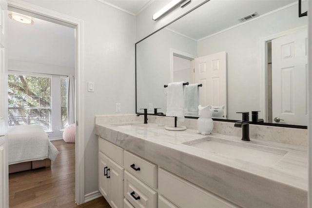 9288 Scenic Bluff Dr, Austin, TX 78733 - bathroom featuring double vanity, wood finished floors, ornamental molding, and ensuite bath