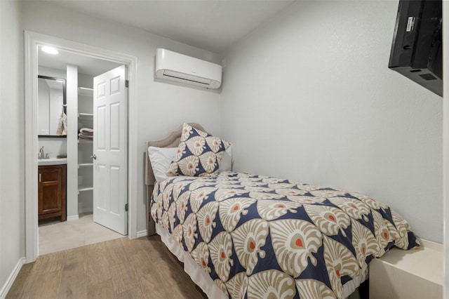 9288 Scenic Bluff Dr, Austin, TX 78733 - bedroom featuring a wall unit AC, wood finished floors, and a walk in closet
