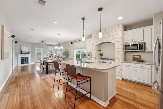 kitchen with visible vents, appliances with stainless steel finishes, white cabinets, and light wood-style flooring