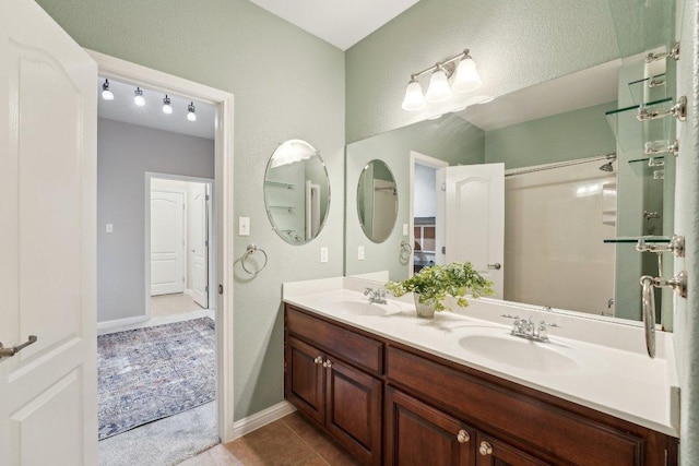 bathroom with double vanity, a sink, and tile patterned floors