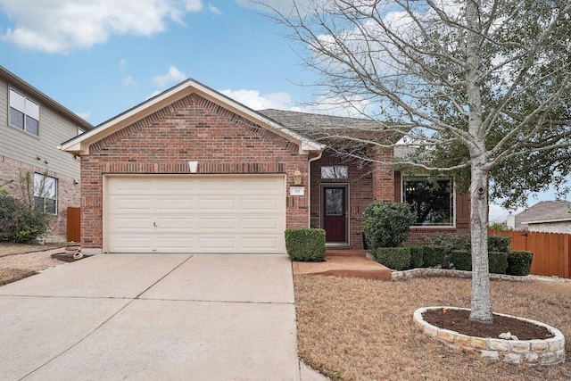 view of front of property featuring an attached garage, driveway, fence, and brick siding