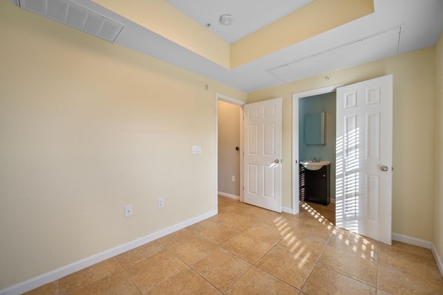 unfurnished bedroom featuring attic access, visible vents, baseboards, and light tile patterned floors