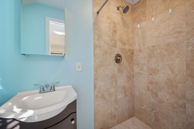 full bath with a tile shower and vanity