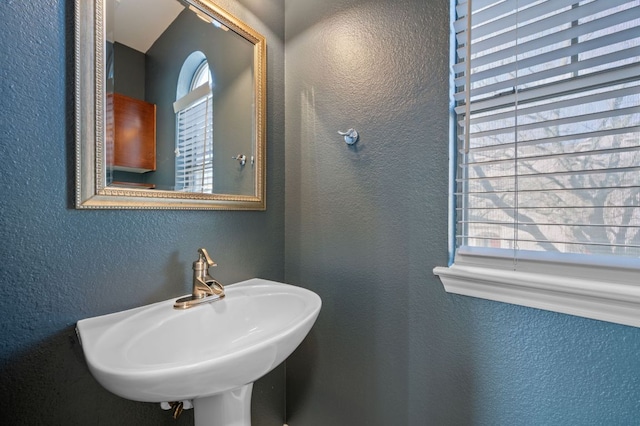 bathroom with a sink and a textured wall