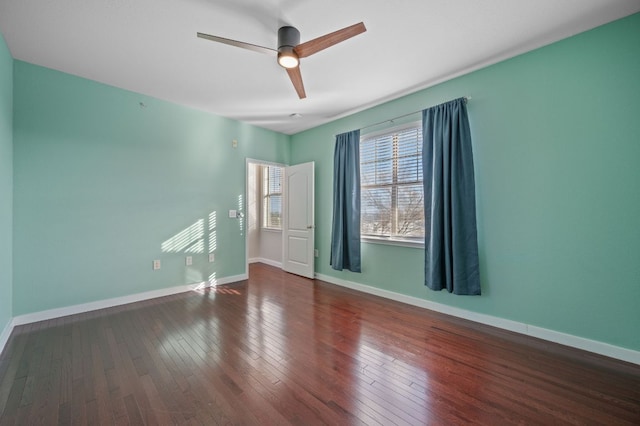 empty room with a ceiling fan, wood-type flooring, and baseboards