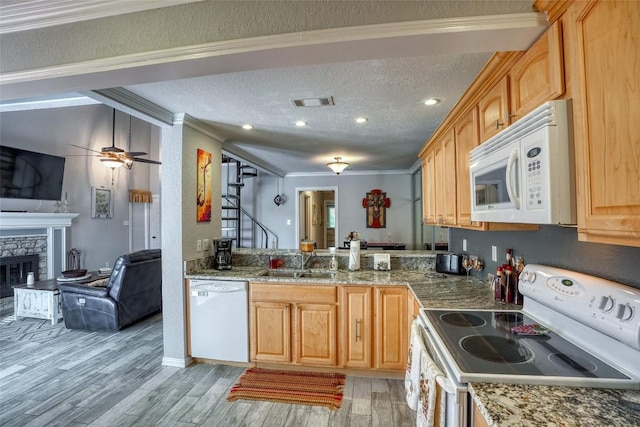 kitchen featuring white appliances, ornamental molding, a textured ceiling, and a stone fireplace