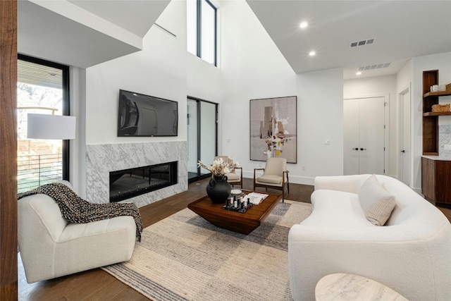 living room with visible vents, a fireplace, and wood finished floors