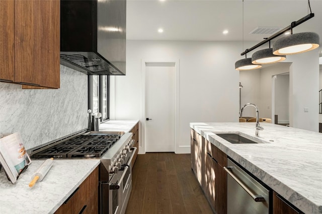 kitchen with extractor fan, stainless steel appliances, a sink, visible vents, and decorative backsplash