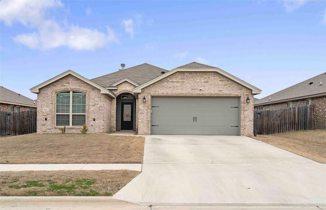 ranch-style home with a garage, brick siding, fence, driveway, and a front yard