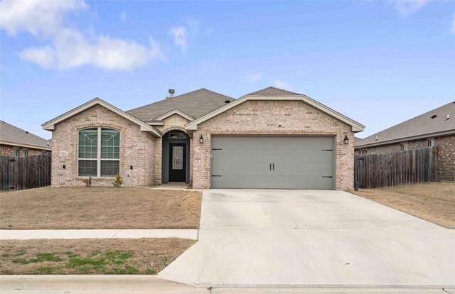 903 Mclaury Cv, Killeen, TX 76542 - view of front of house with brick siding, a garage, concrete driveway, and a shingled roof