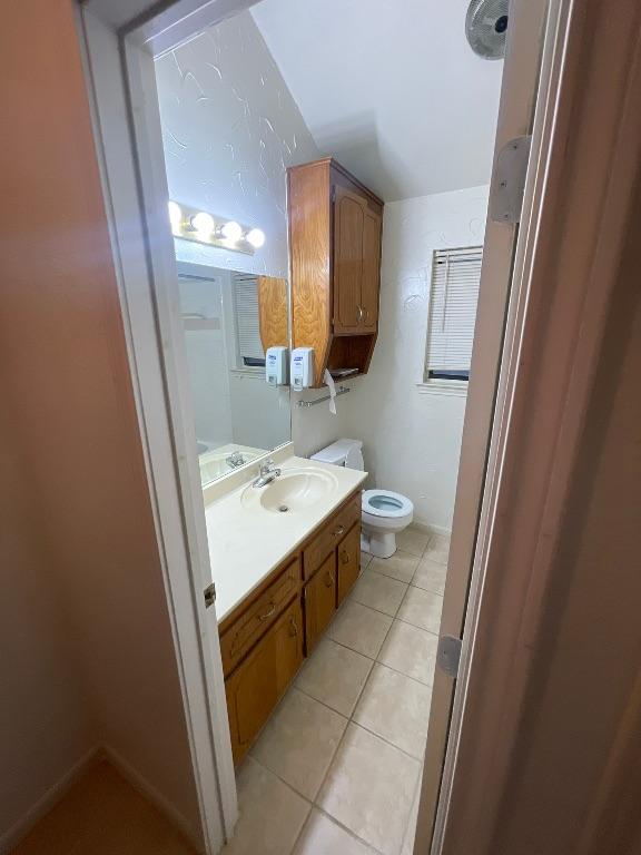 half bathroom with vanity, toilet, and tile patterned floors