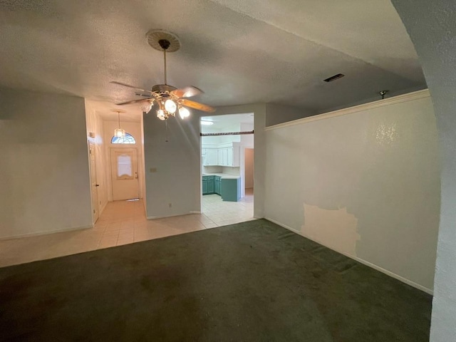 interior space with light tile patterned floors, visible vents, a textured ceiling, and light colored carpet