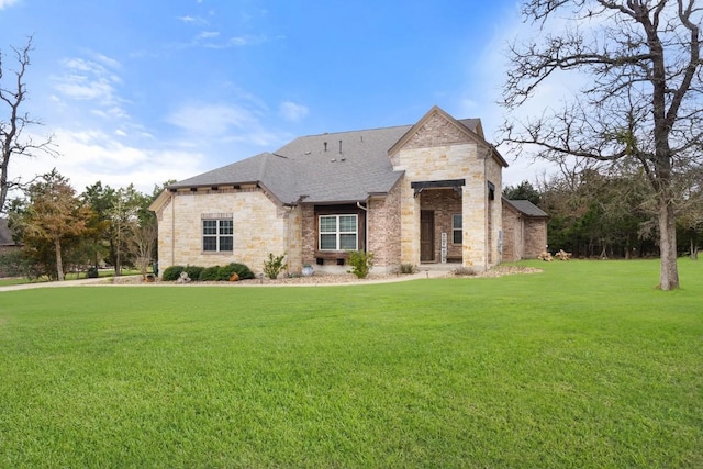 french country home featuring a shingled roof, a front lawn, and brick siding