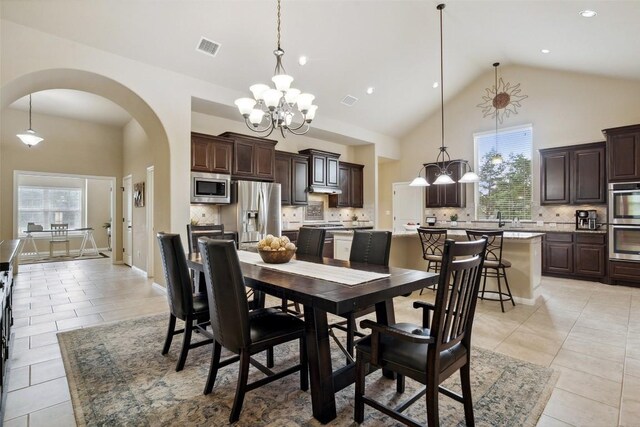 dining room with arched walkways, a notable chandelier, light tile patterned flooring, and visible vents