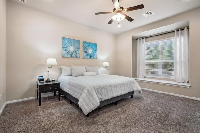 carpeted bedroom featuring baseboards, a ceiling fan, and visible vents