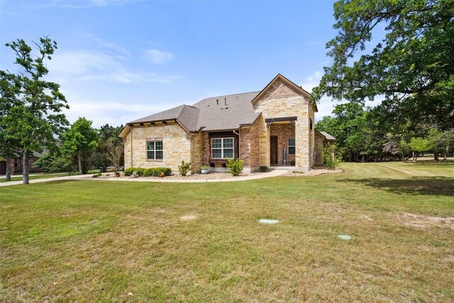 view of front of house with a front yard and stone siding