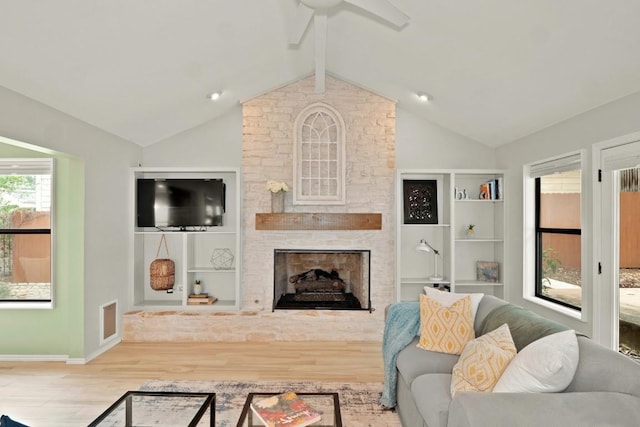 living room featuring built in features, a fireplace, lofted ceiling with beams, ceiling fan, and wood finished floors