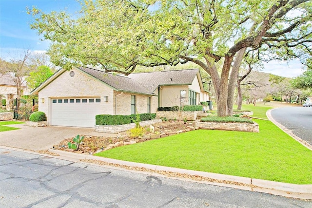 view of front of home featuring driveway, an attached garage, and a front lawn