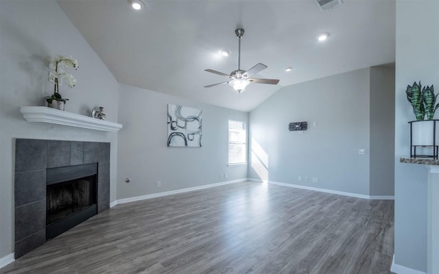 unfurnished living room featuring visible vents, a tiled fireplace, lofted ceiling, ceiling fan, and wood finished floors