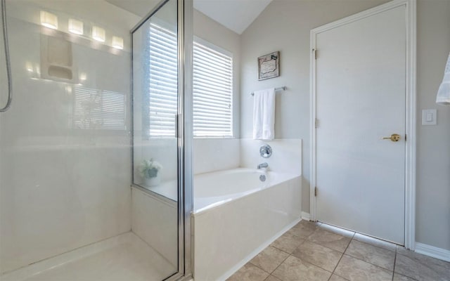 bathroom featuring a shower stall, vaulted ceiling, a bath, and tile patterned floors