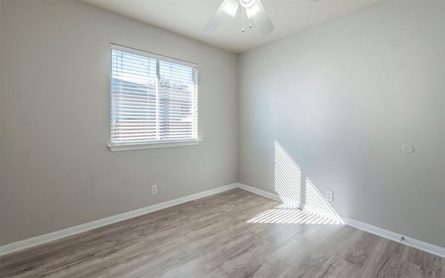 empty room with wood finished floors, a ceiling fan, and baseboards