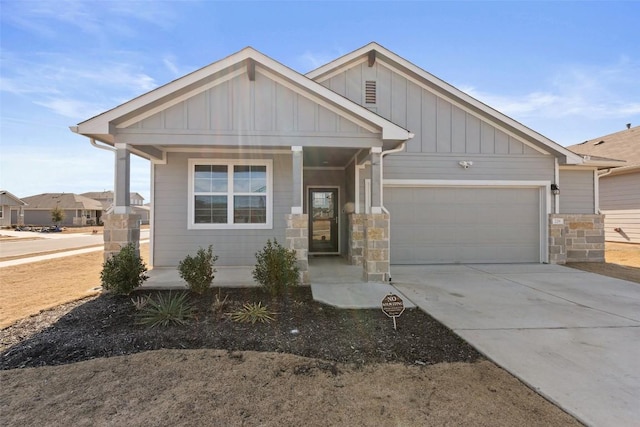 view of front of property featuring a porch, board and batten siding, concrete driveway, and a garage