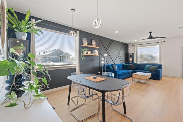 dining area with visible vents, baseboards, ceiling fan, and light wood finished floors