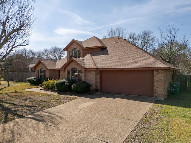 view of front of house with a garage, driveway, a shingled roof, fence, and brick siding