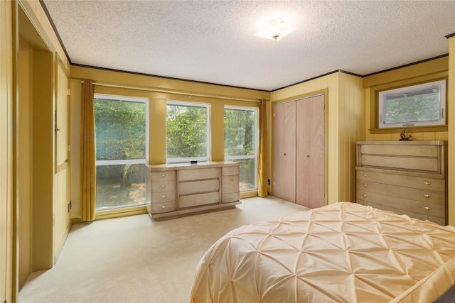 bedroom with a textured ceiling, a closet, and light colored carpet