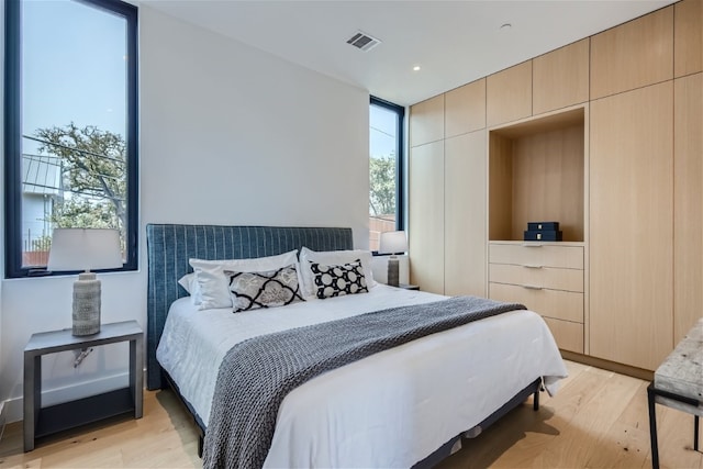 bedroom with light wood-type flooring and visible vents