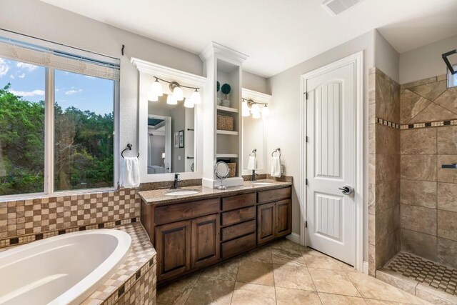 full bathroom with a garden tub, a sink, visible vents, tiled shower, and double vanity