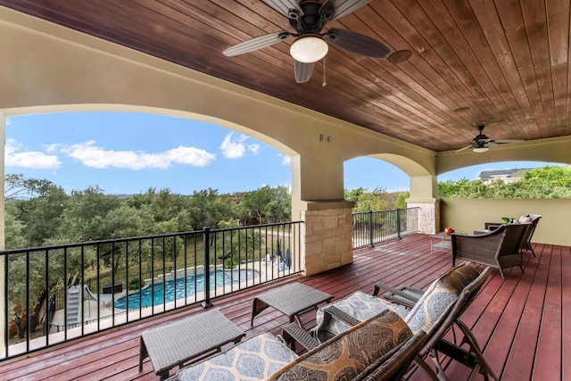 deck featuring a fenced in pool, outdoor lounge area, and a ceiling fan