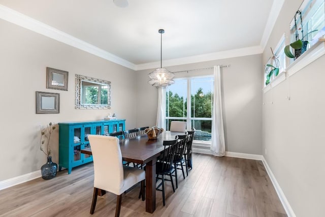 dining space featuring crown molding, baseboards, and wood finished floors