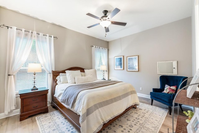 bedroom with a ceiling fan, light wood-type flooring, and baseboards