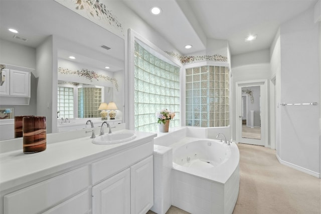 bathroom featuring a whirlpool tub, a wealth of natural light, and visible vents