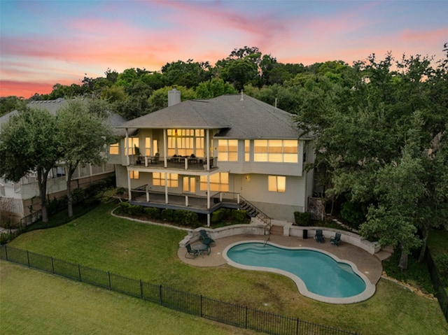 rear view of property with a fenced backyard, a yard, stairway, a chimney, and a patio area